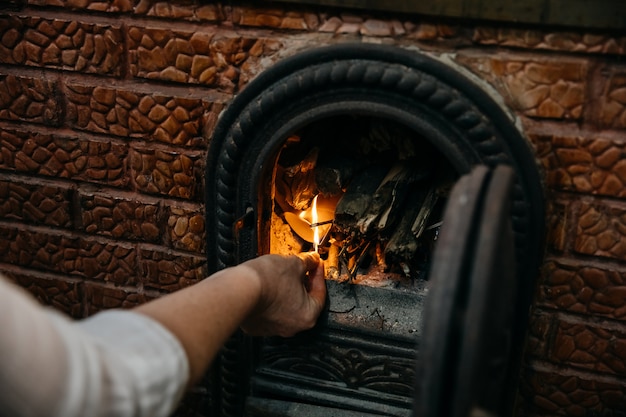 Main féminine éclairer le feu dans une cheminée