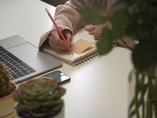 main féminine écrit sur un cahier vierge