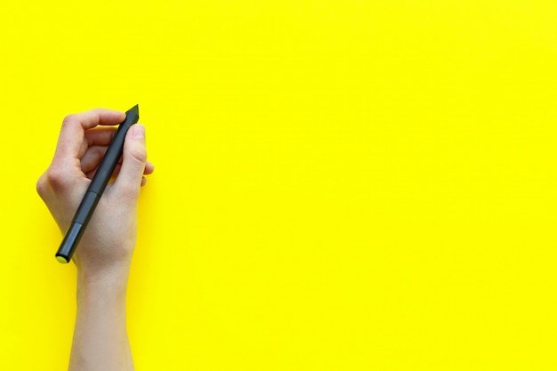 La main féminine fait un record sur un tableau jaune monochrome