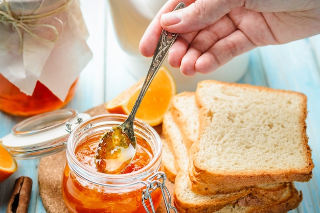 Main féminine, frottis, toasts, à, confiture orange maison