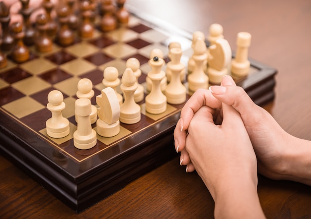 Une main féminine joue aux échecs.