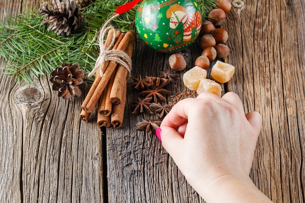 Main féminine met les épices de Noël, la cannelle, l'anis