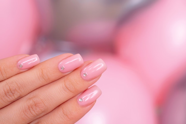 Main féminine avec des ongles de manucure romantique