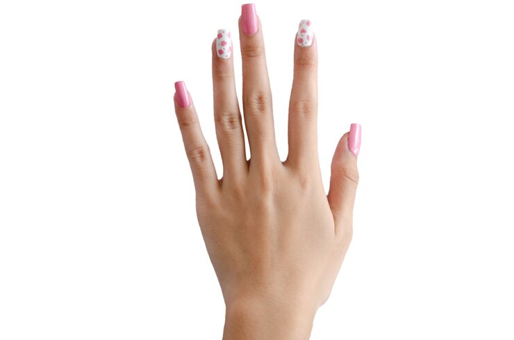 Photo main féminine peinte de beaux ongles roses sur fond blanc