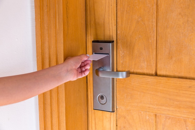 Une main féminine qui met et tient un commutateur à carte magnétique pour ouvrir la porte de la chambre d&#39;hôtel