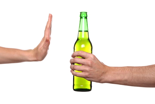 Main féminine refusant une bouteille de bière sur fond blanc