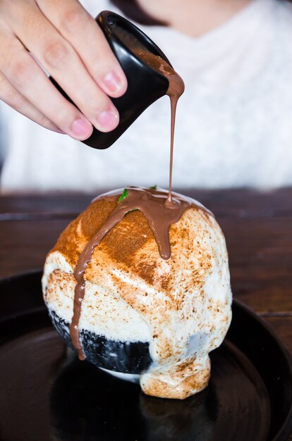 main féminine tenant une tasse de chocolat sur Bingsu