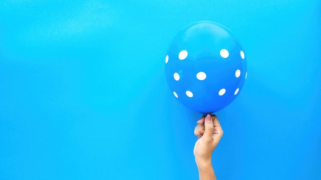 Main féminine tient un ballon avec des cercles blancs