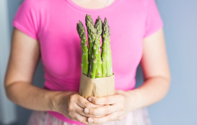 La Main Féminine Tient Un Paquet D'asperges Vertes Concept De Végétaliens Végétariens Et D'aliments Sains