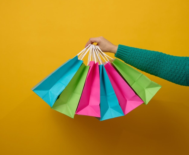 La main féminine tient un sac jetable en papier avec des poignées pour l'épicerie et les vêtements Emballage recyclable Vente zéro déchet