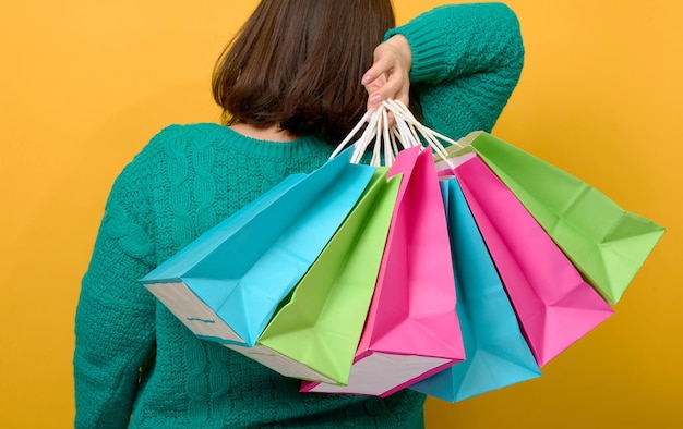 La main féminine tient un sac jetable en papier avec des poignées pour l'épicerie et les vêtements. Emballages recyclables. Zero gaspillage. Vente