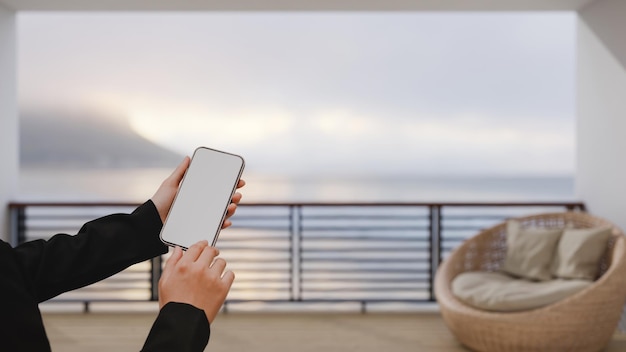 Une Main Féminine Utilisant Un Smartphone Sur Un Intérieur De Balcon Confortable Et Moderne Flou