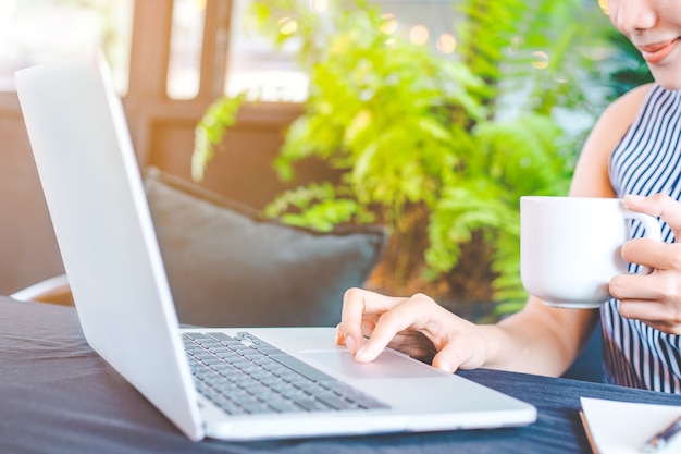 Main de femme d&#39;affaires écrit sur le bloc-notes