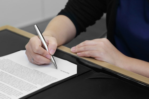 main de femme d&#39;affaires signature du contrat avec un stylo