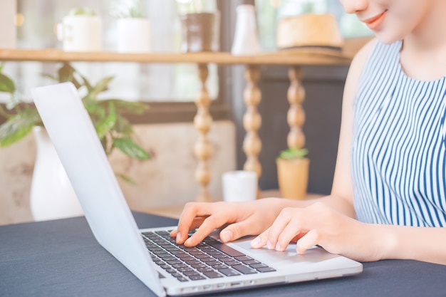 Main de femme d&#39;affaires travaillant avec un ordinateur portable au bureau.