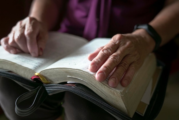 Main de femme agée sur un livre ouvert