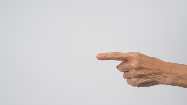 La main de femme âgée ou plus âgée pointe sur fond blanc.