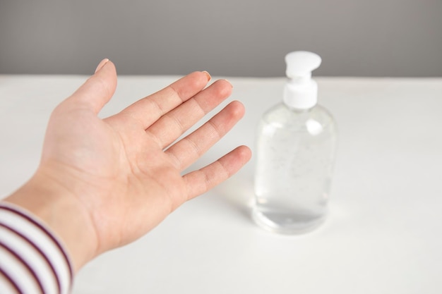 Main de femme à l'aide de gel de lavage à l'alcool