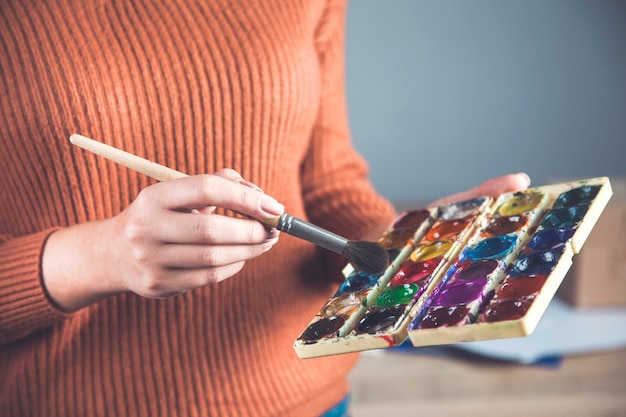 Photo main de femme aquarelle et pinceau