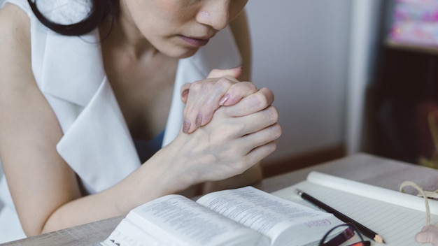 Main de femme avec Bible priant dans le christian
