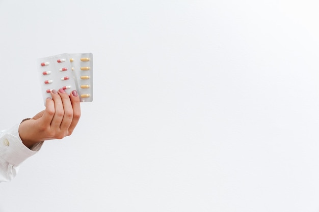 Main de femme avec blister de pilules avec capsules. Concept de traitement médical d'assurance médicale.