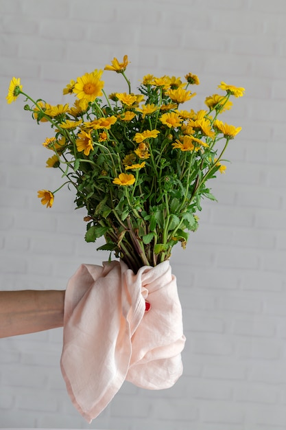 Main de femme avec bouquet de fleurs fraîches de printemps