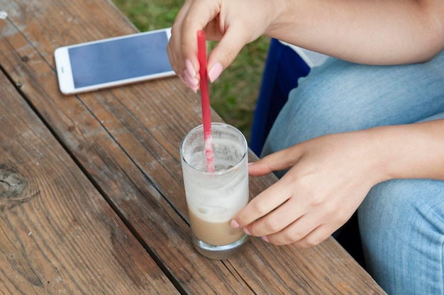 Main de femme café et téléphone