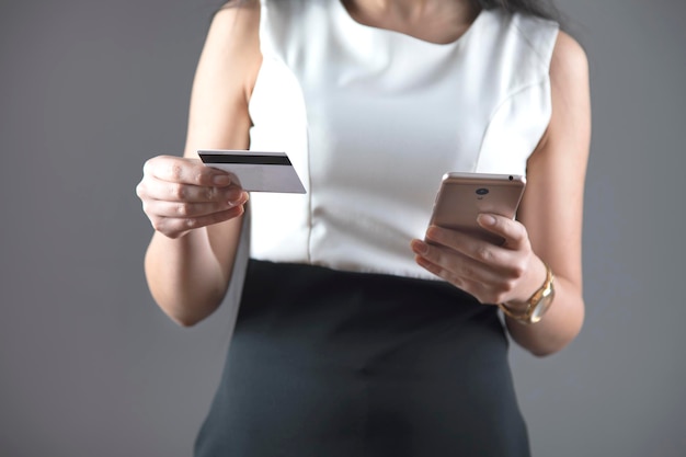 Main de femme carte de crédit et téléphone