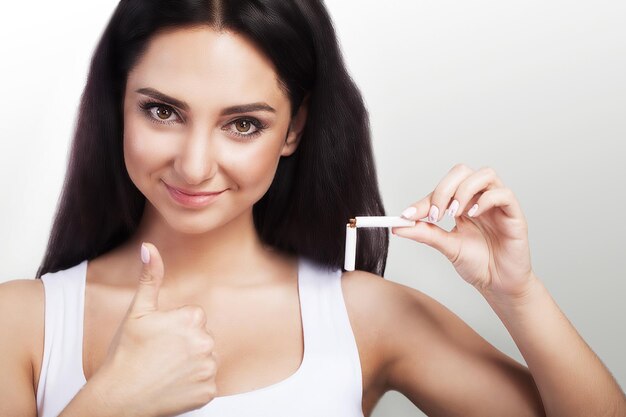 Main de femme avec une cigarette cassée