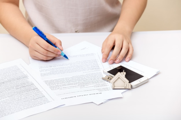 Main De Femme Et Clé De La Maison. Contrat Signé Et Clés De La Propriété Avec Documents. Concept Pour De Vrai E