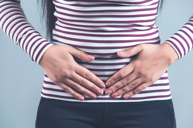 Main de femme dans les ovaires douloureux