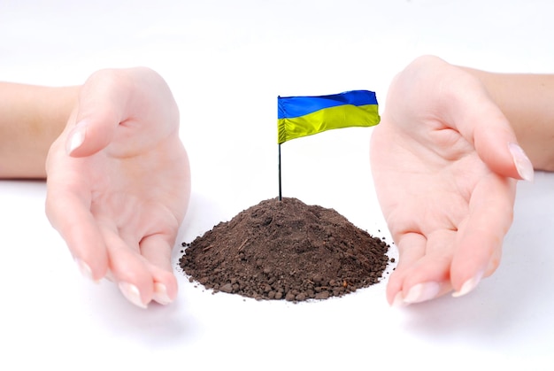 Main de femme et drapeau ukrainien sur fond blanc