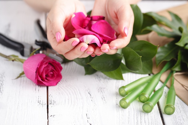 Main d'une femme fleuriste pleine de pétales de rose pour le mariage