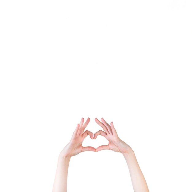 Main de femme formant la forme de coeur sur fond blanc