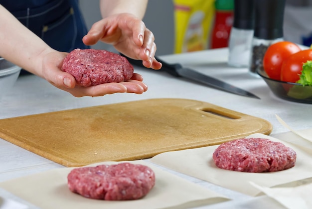 Main de femme formant une viande de boeuf pour une partie de hamburger Portionnement de la viande hachée Burgers faits maison Faire de la nourriture à la maison en gros plan