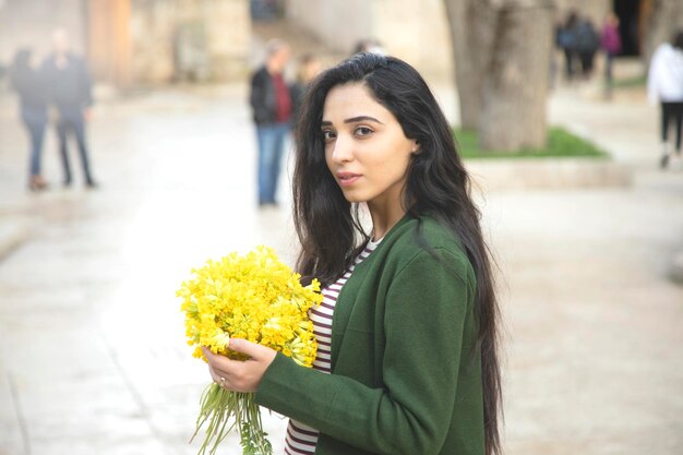 Main de femme heureuse fleurs jaunes