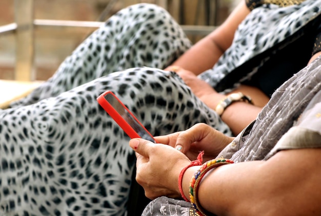 Main de femme indienne à l'aide de téléphone portable