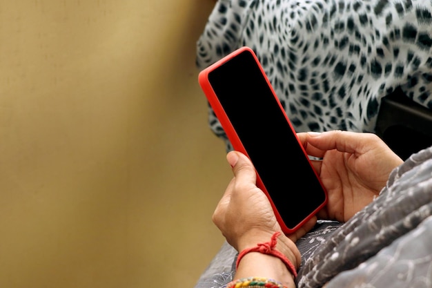 Main de femme indienne à l'aide de téléphone portable