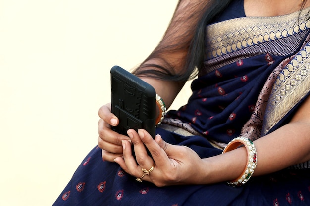Main de femme indienne à l'aide de téléphone portable