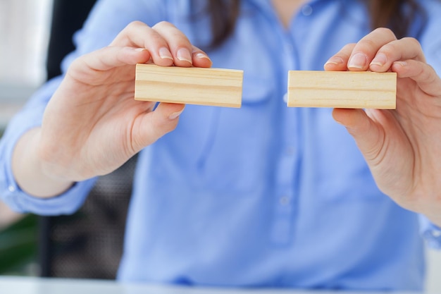 Main de femme d'ingénieur jouant un bloc de bois