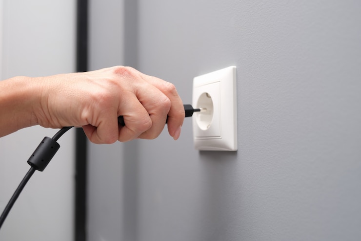 Photo la main de femme insère une prise électrique dans le plan rapproché de prise