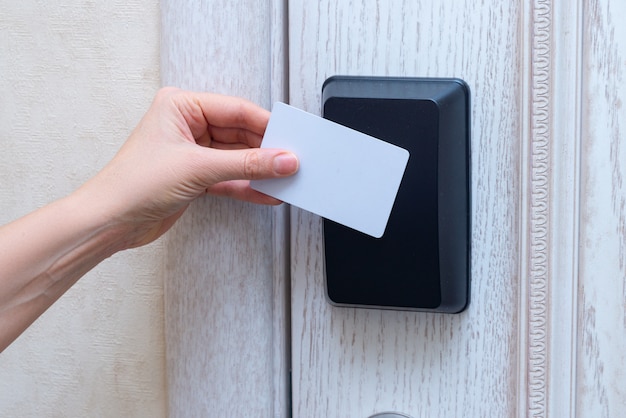 Main de femme ouvrant la porte de l'hôtel avec carte