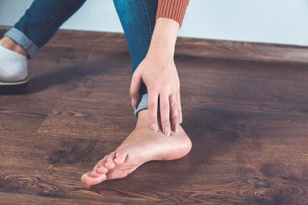 Main de femme sur les pieds douloureux