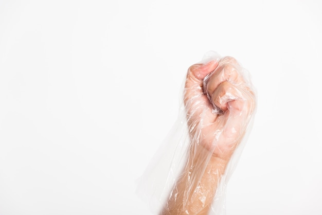 Main de femme portant un gant en plastique transparent jetable à usage unique