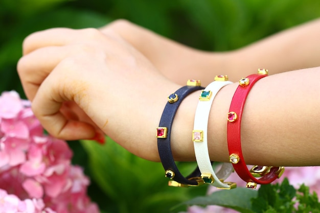 Une main de femme porte un bracelet de la collection de la marque.