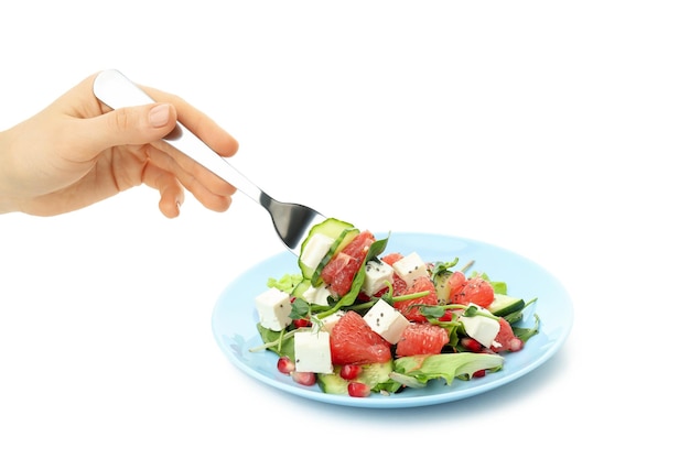 La main d'une femme prend une salade avec une orange rouge avec une fourchette isolé sur fond blanc