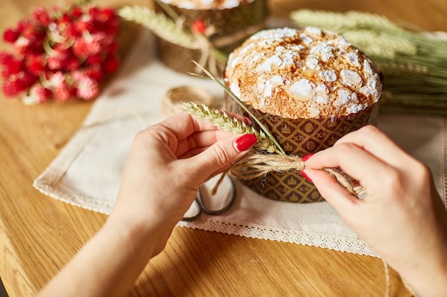 Main de femme préparant un gâteau avec une décoration rustique pour les vacances de Pâques