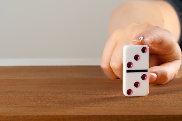 Main de femme renversant les dominos. Concept d'entreprise de réaction en chaîne