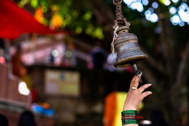 Main d'une femme sonnant la cloche dans le temple.