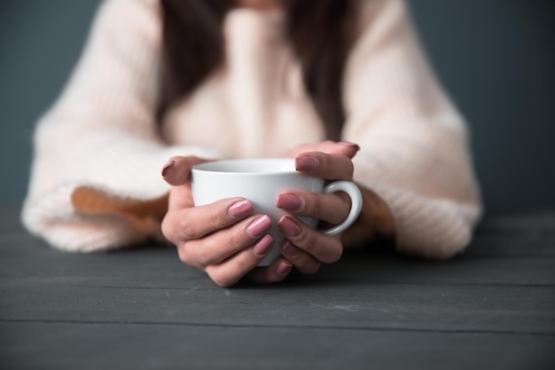 Main de femme tasse de café